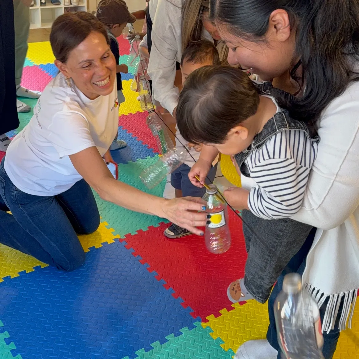 Miss Rebeca leading a sensory Spanish activity with a child and parent